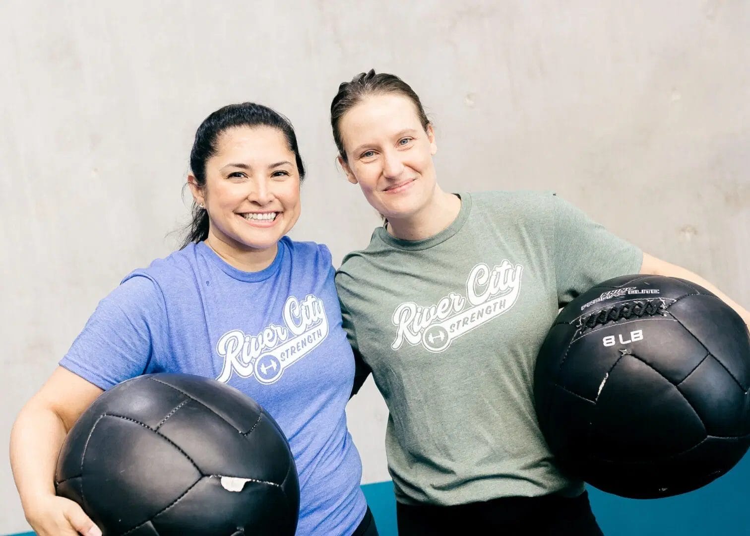 Female members at River City Strength smiling.